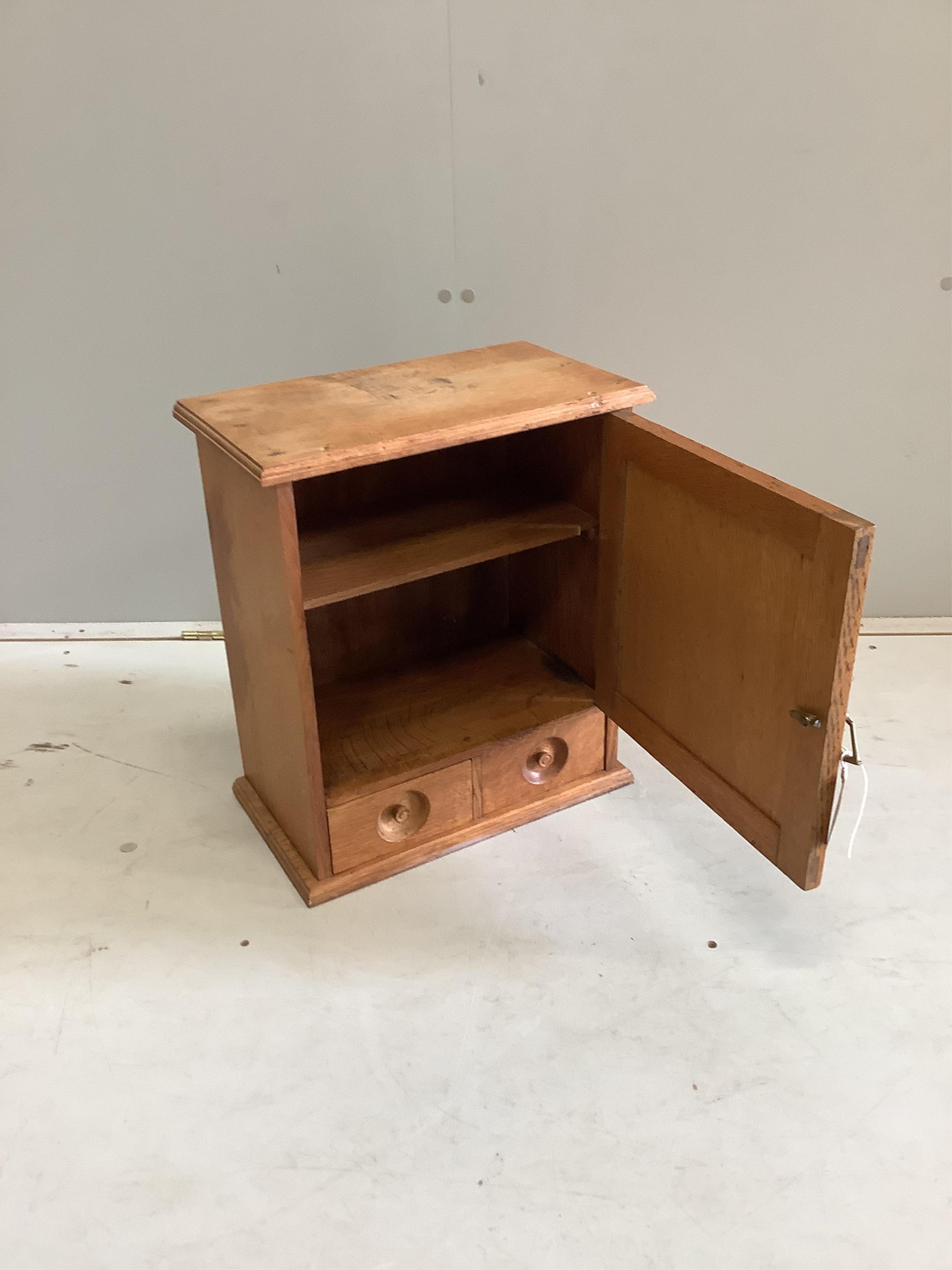 A late Victorian bleached oak two drawer smoker's cabinet, width 39cm, depth 22cm, height 45cm. Condition - fair